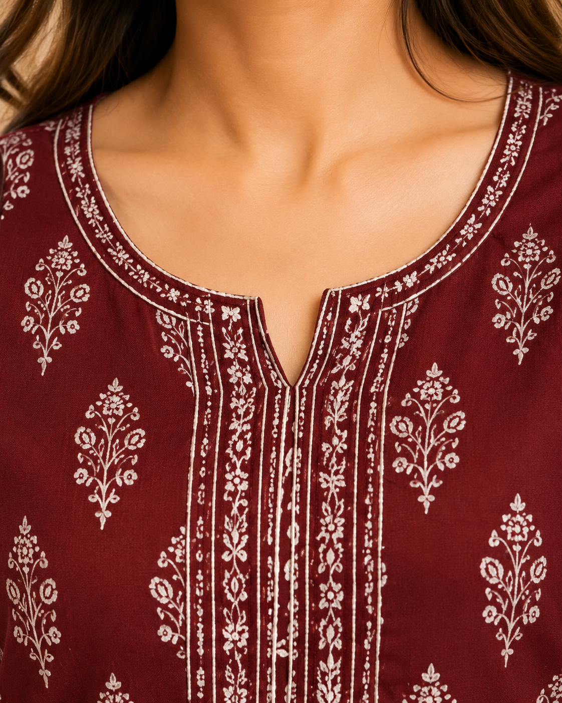 Close-up macro view of the Ebunic maroon cotton printed kurta neckline featuring precise stitching, slit neckline, piping, button detail, and premium cotton fabric texture with aligned ethnic print.