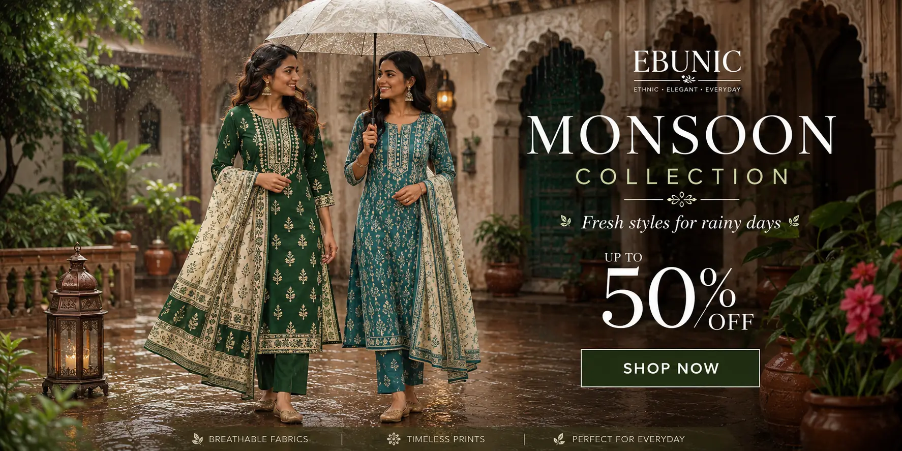Two Indian women wearing elegant emerald green and teal blue printed cotton kurta sets walk through a rain-kissed heritage courtyard, showcasing Ebunic's Monsoon Collection with an Up to 50% Off offer.